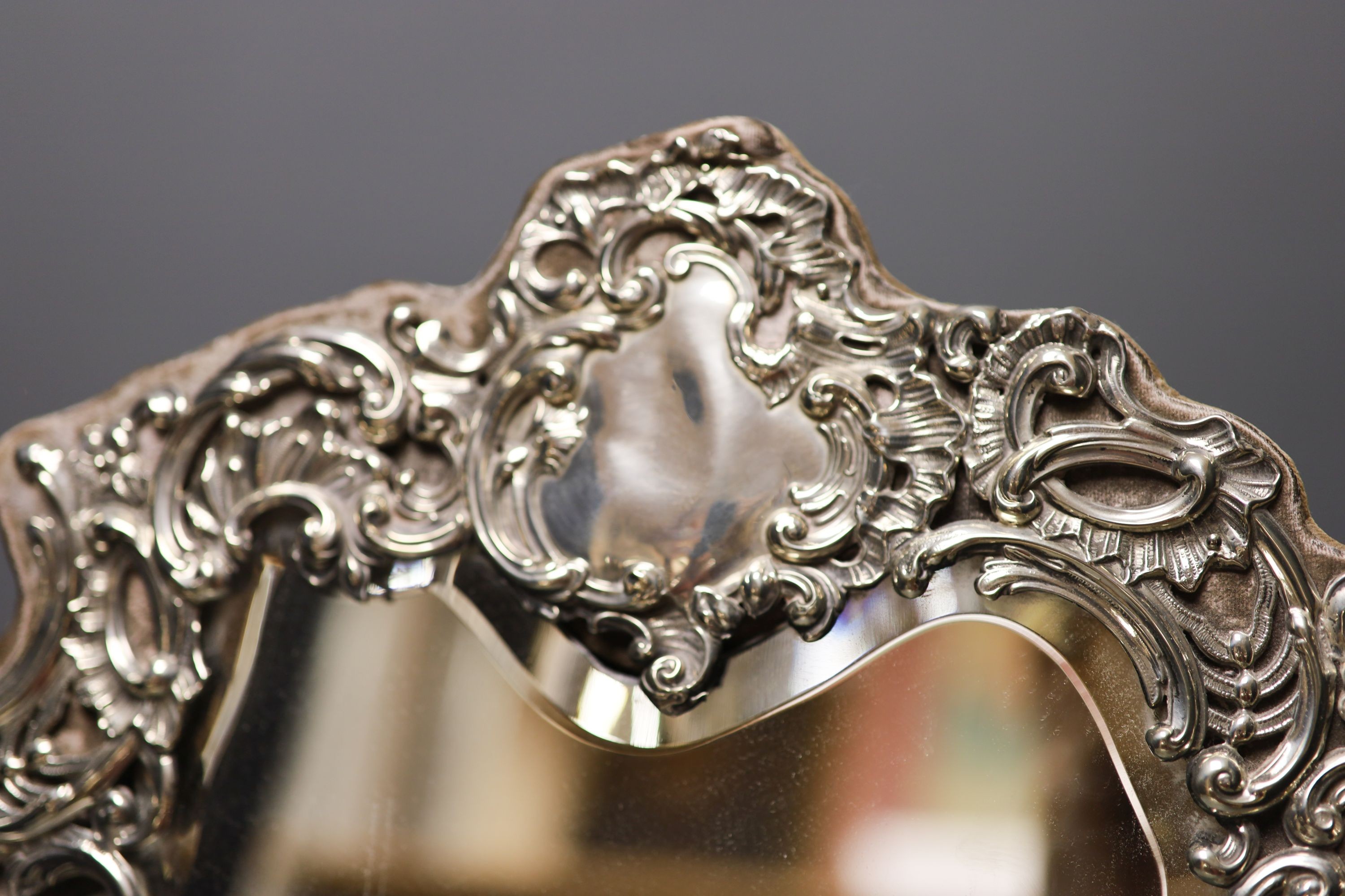 An Edwardian repousse silver mounted easel mirror, with foliate scroll decoration, Chester, 1902, height 45.7cm.
